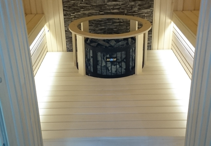Kompaktowa sauna z charakterystyczną ścianą kamienną