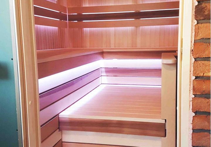 Sauna z piecem opalanym drewnem i zewnętrznym paleniskiem