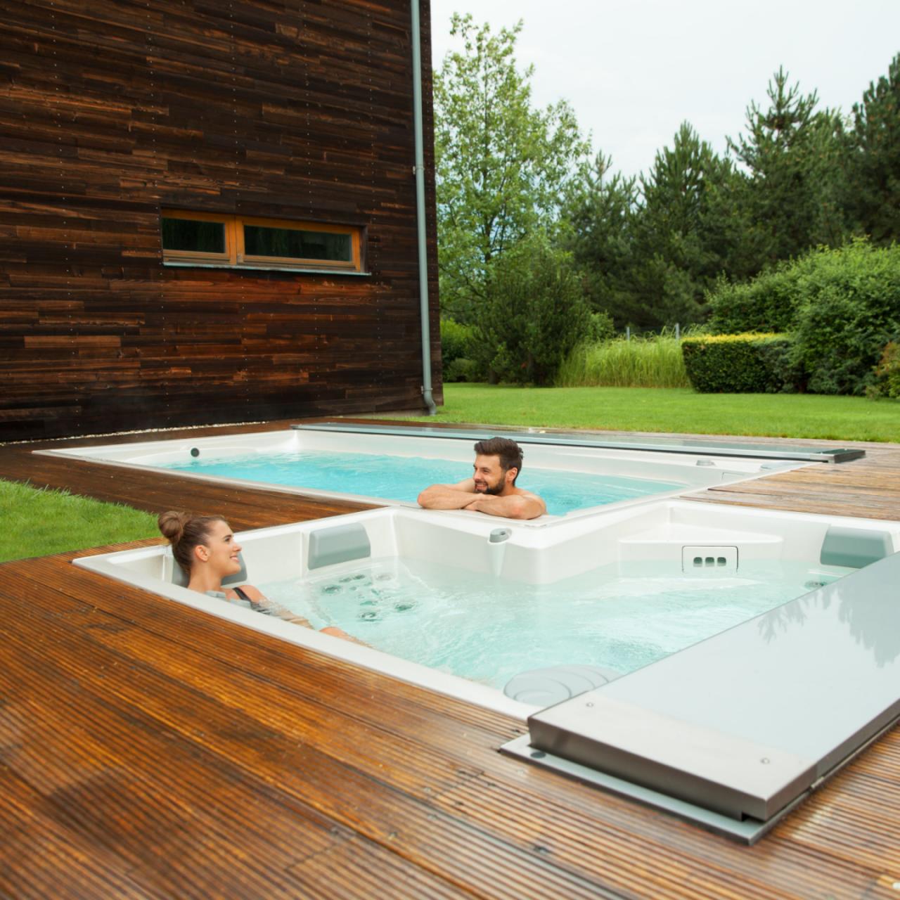 Para relaksująca się w zewnętrznym spa USSPA i basenach spa zainstalowanych na drewnianym tarasie