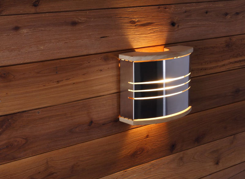 Lampa ścienna do sauny, wykonana z metalu i drewna, montowana na ścianie sauny.