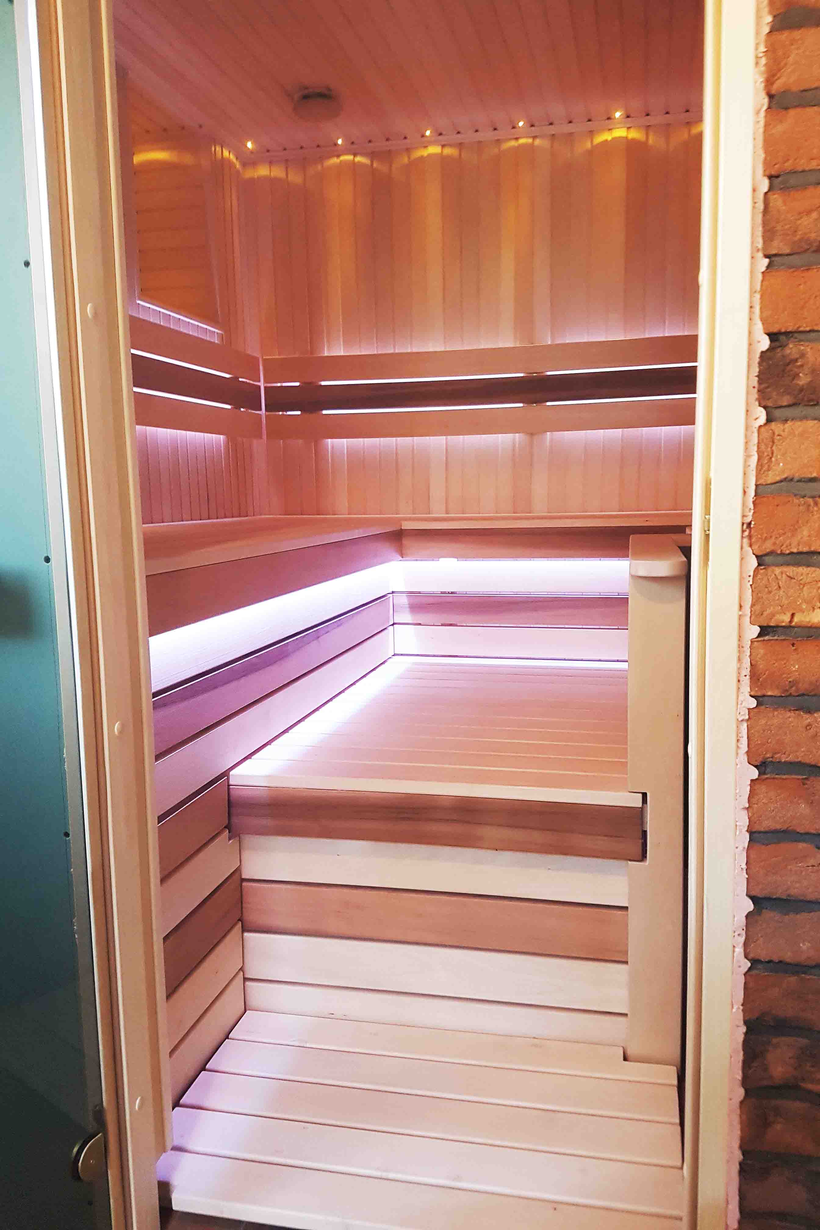 Sauna z piecem opalanym drewnem i zewnętrznym paleniskiem